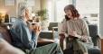 Psychologist, chat and senior woman with notes and smile from mental health assessment in consultation. Writing, support and care with counseling, psychology and evaluation with advice in office